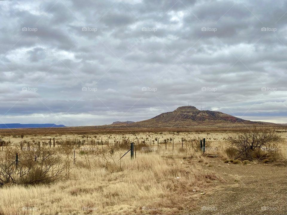 Rolling clouds in New Mexico desert with mountain background