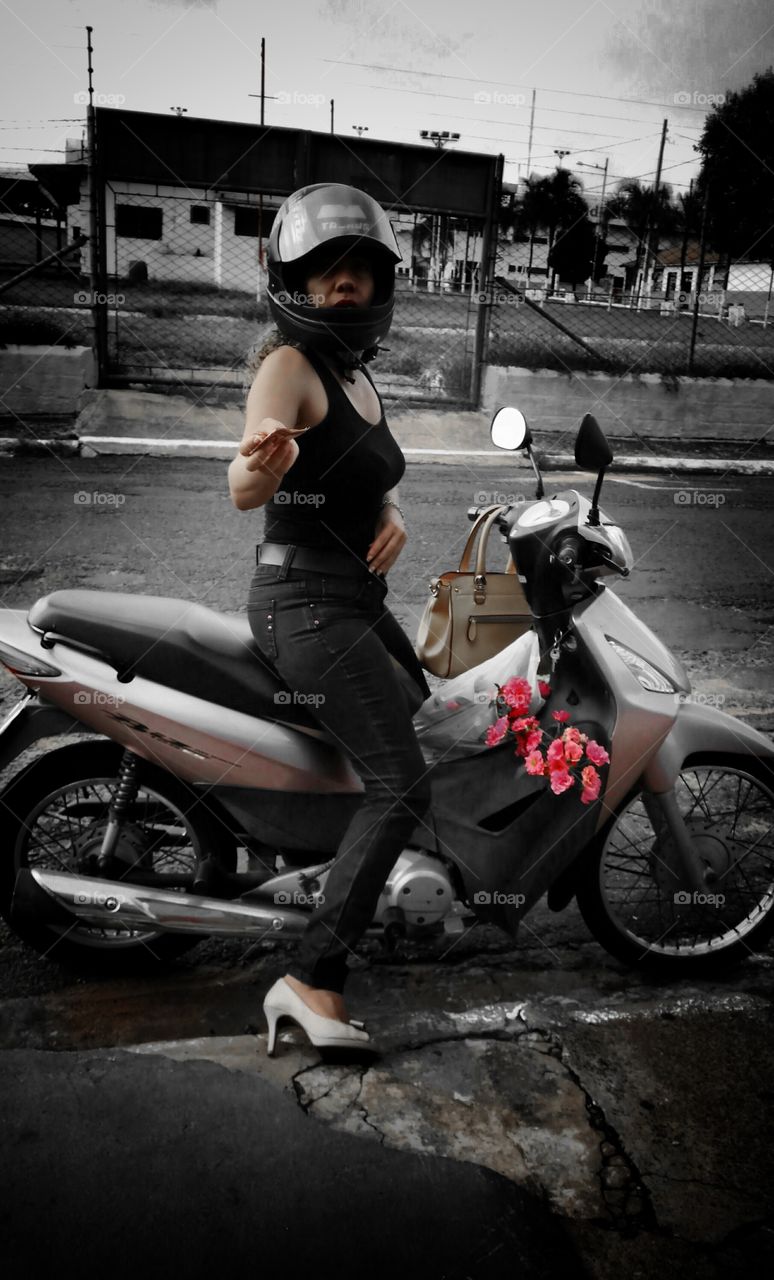 Moça em motocicleta com buquê de flores, bonitas rosas, Dinheiro na mão fazendo um pagamento.