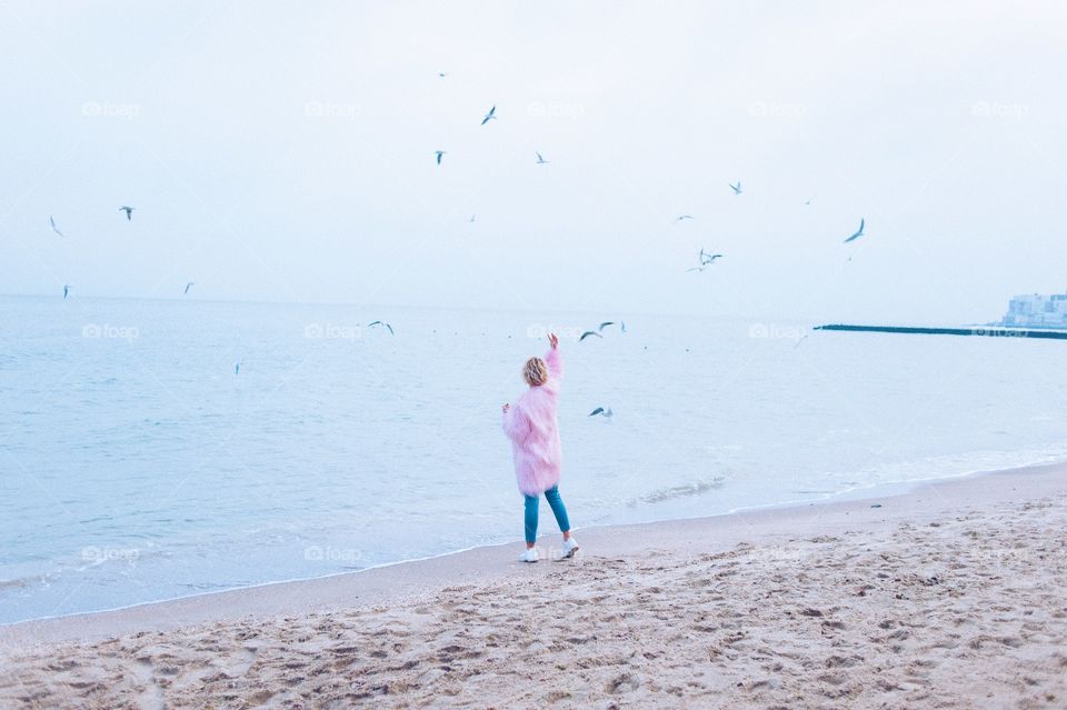 girl feeding birds on the seashore