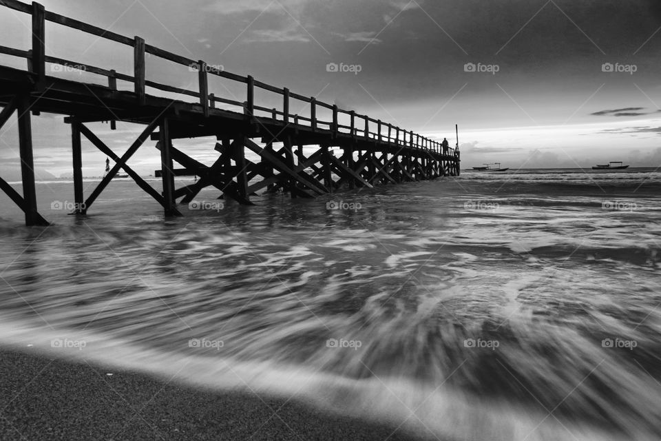 Sunrise at Angsana Beach, South Borneo, Indonesia. Motion Waves under bridge.