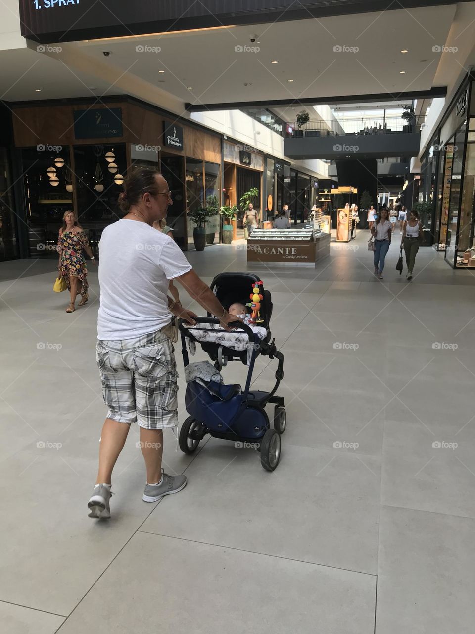 a grandfather walking with a grandson in a stroller, in the background you can see the panorama of the city