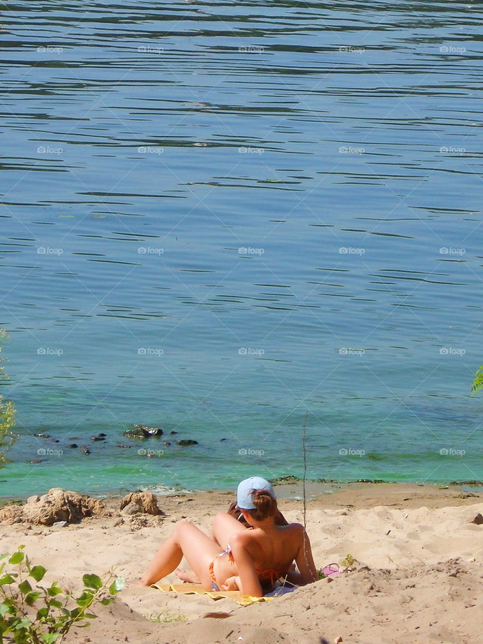 girl sunbathing on the beach on the Dnieper river in the city of Kiev, Ukraine