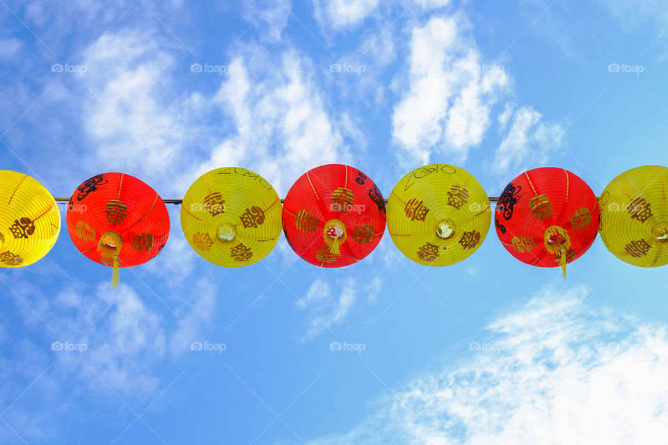 Red and yellow chinese lanterns, Blue sky background.