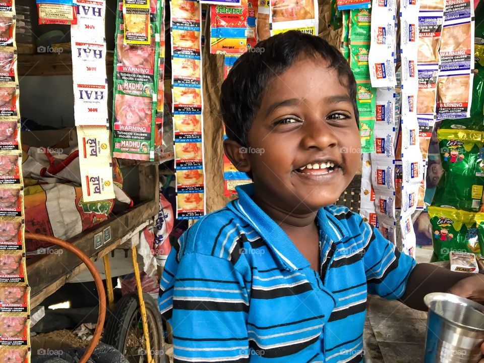Happy Indian kid in his parents shop