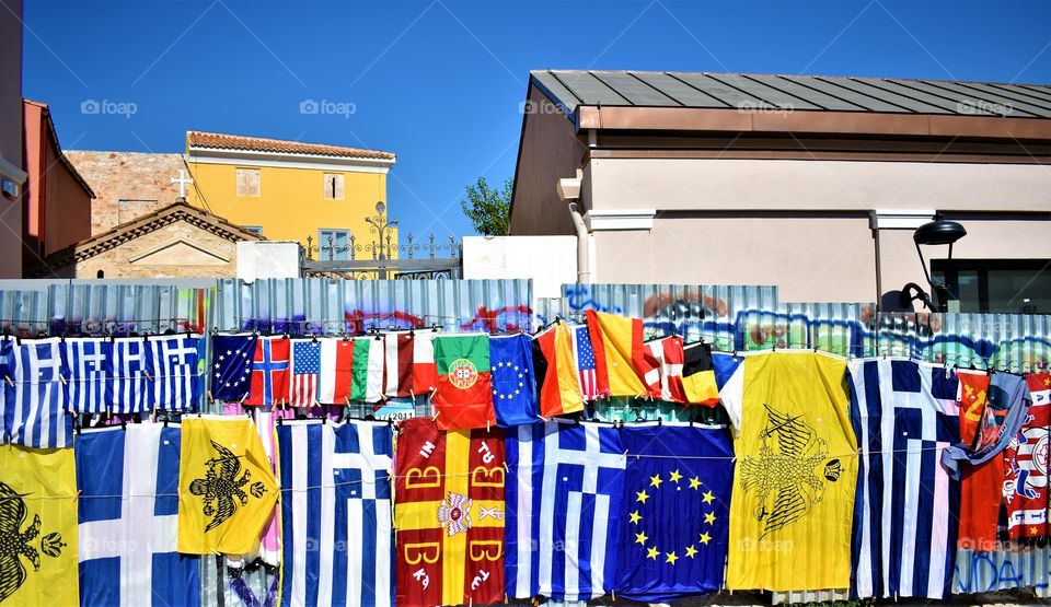 Greek flags over graffiti fence
