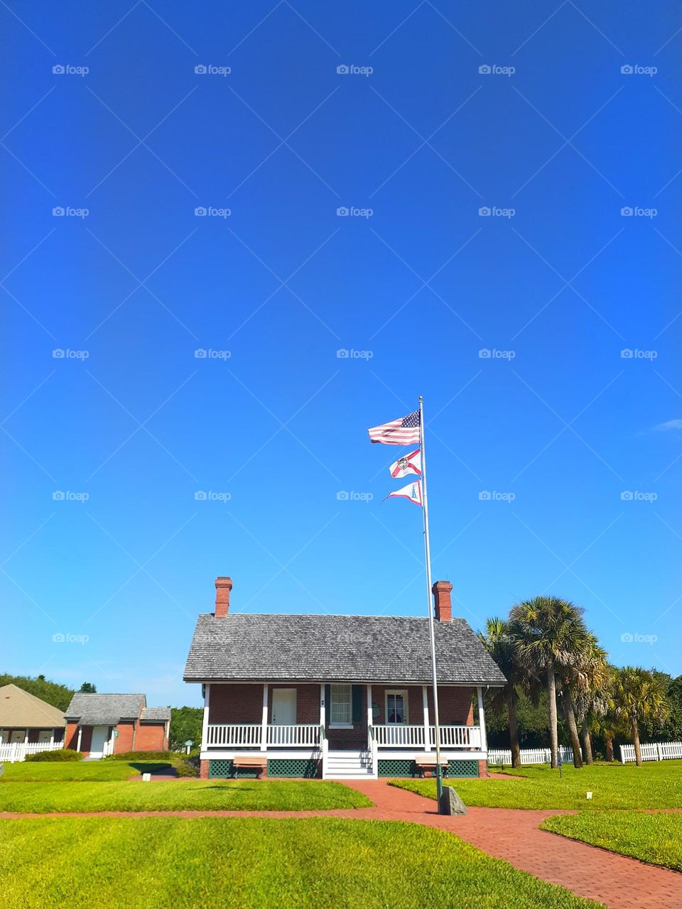 A small house with a flagpole in front of it is part of the Ponce Inlet Museum, in Ponce Inlet, Florida.