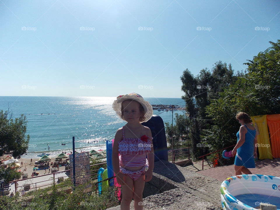 Cute little girl standing in front of beach