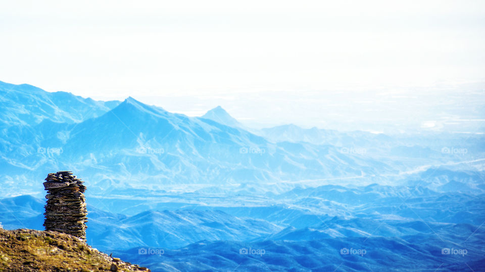 Zen balanced stones against blue Misty mountains in Spain.