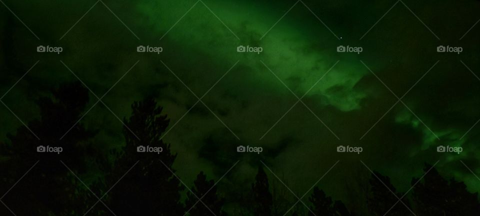 Beautiful green clouds illuminated with auroa