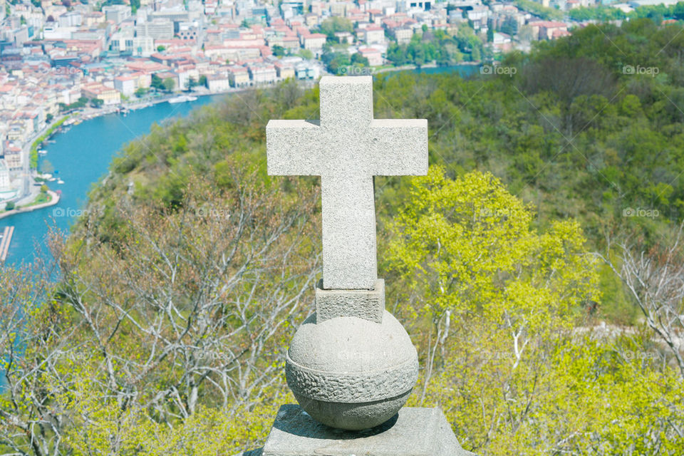 view of lugano from san salvatore mountain with a cross in front .