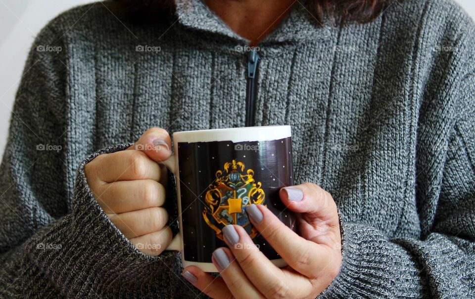 Woman wearing gray tracksuit holding a mug