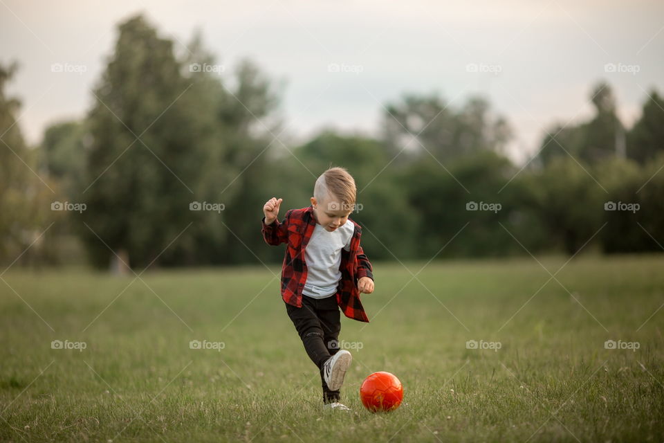 Little boy playing in soccer in a park 