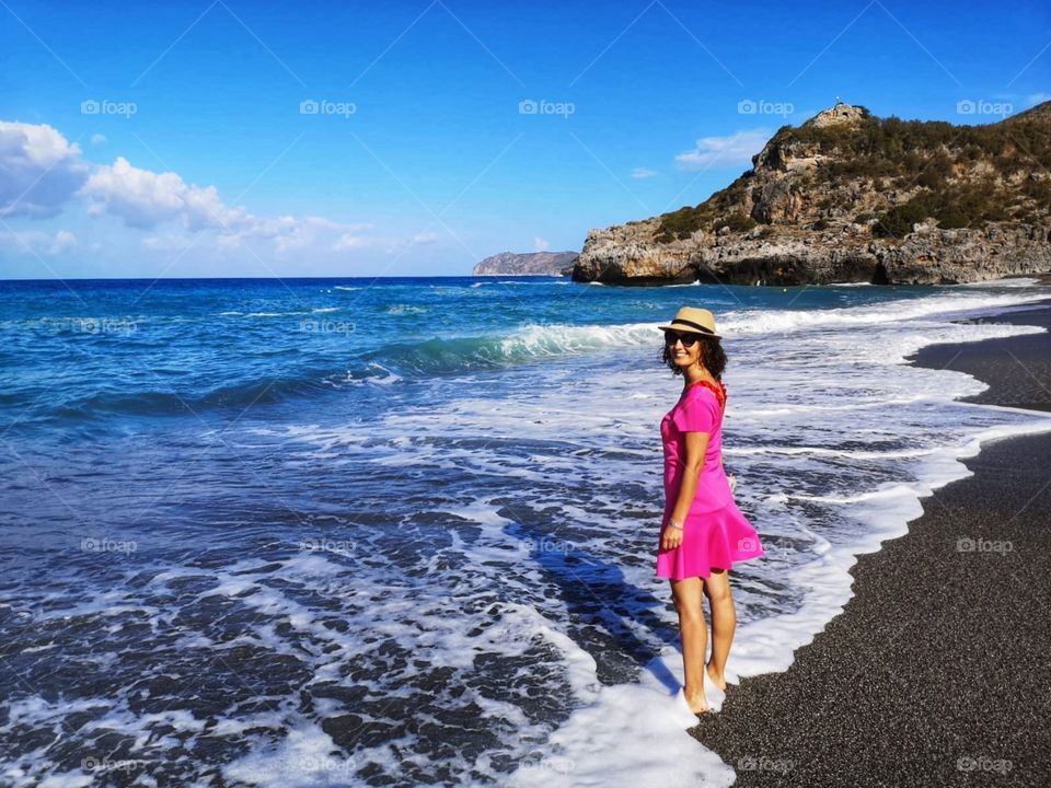 Smiling woman wets her feet in the sea of ​​marina di camerota