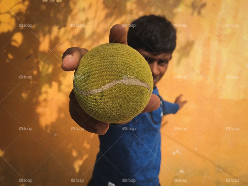 Indian kid playing with a ball