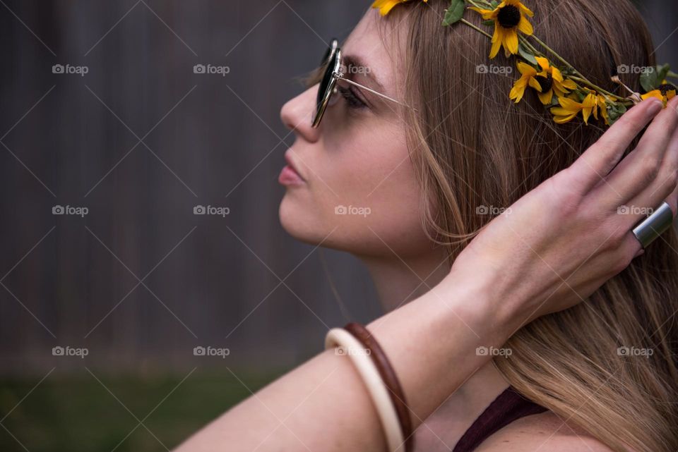Profile selfie of a woman wearing a flower crown and sunglasses outdoors 