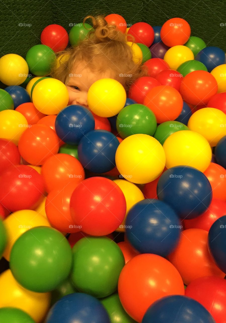 Kid playing in ball pit 