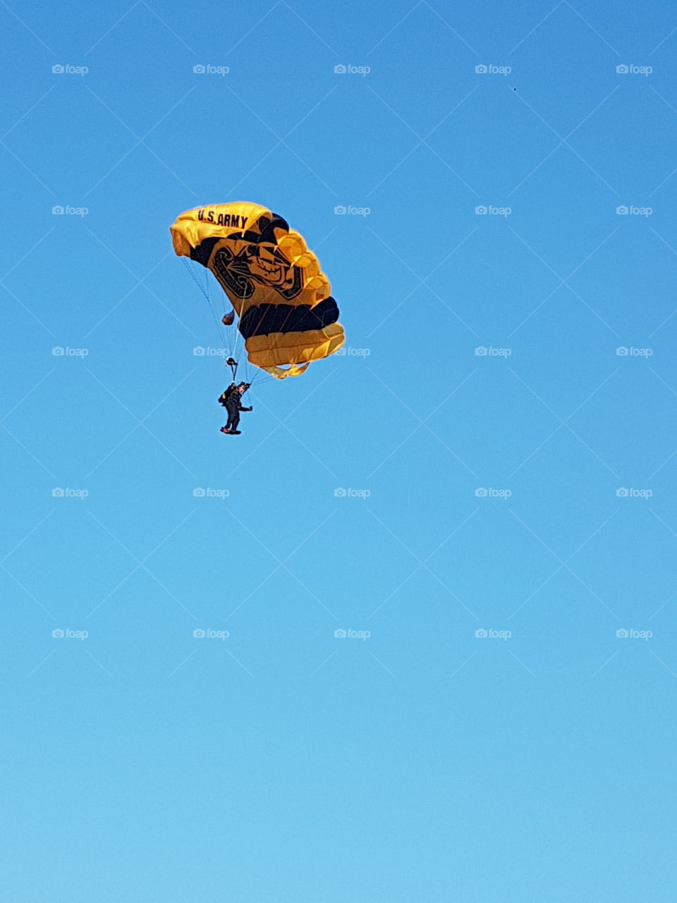 US Army Golden Knights parachuting in bright blue sky