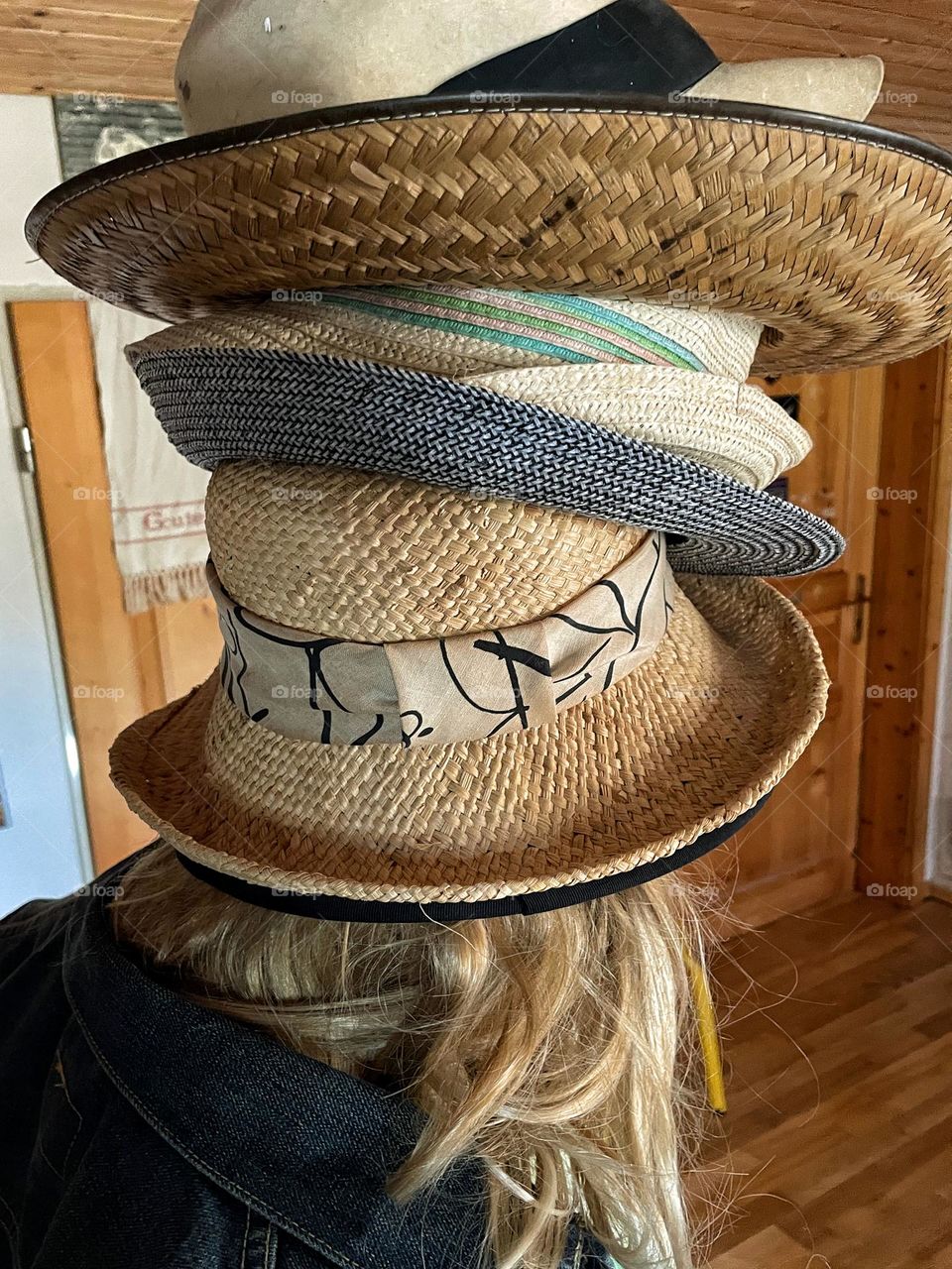 Rear view of a woman wearing stacked straw hats 
