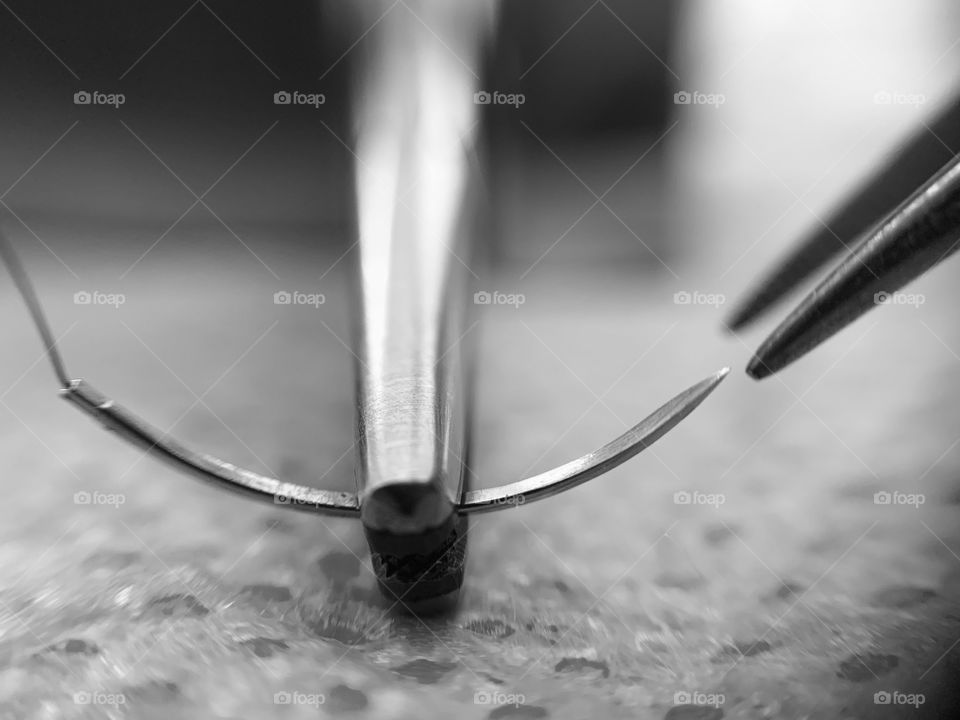 Macrophotography of surgical material: needle holder,  suture needle and fórceps 