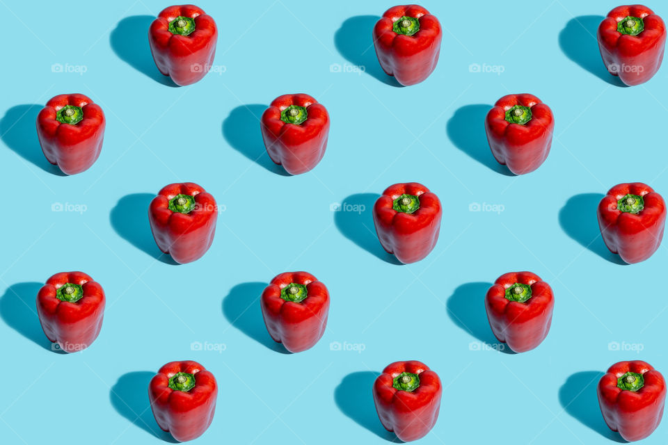 Pattern of red peppers on blue background. Flat lay