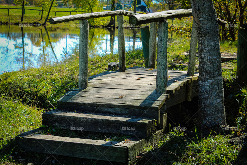 Trialhead bridge to walking path on a small lake in summer. 