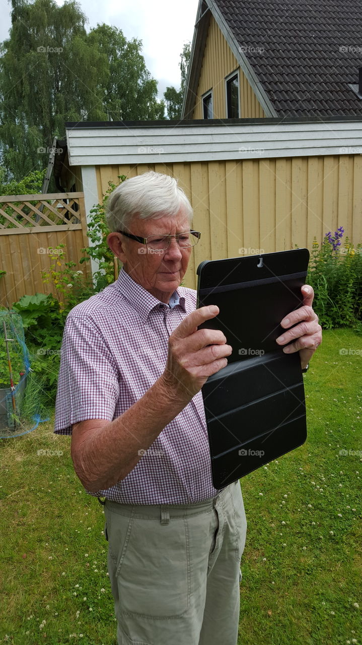 Grandpa using tablet. Senior tablet usage & photography
