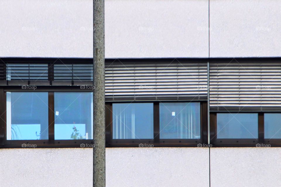 Close-up of blue colored windows with blinds on a white building