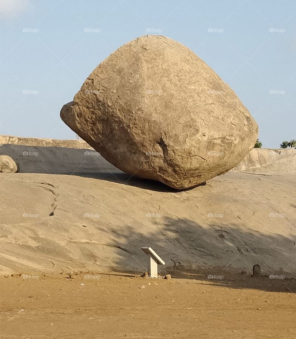 Krishna's Butter ball is a gigantic granite boulder resting on a short incline in the historical coastal resort town of mamallapuram in tamilnadu state of India. The boulder is approximately 6 meters high and 5 meters wide and weighs around 250 tons.