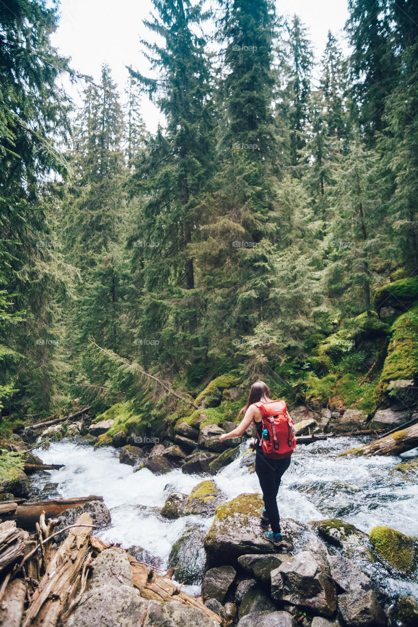 woman standing next to a waterfall