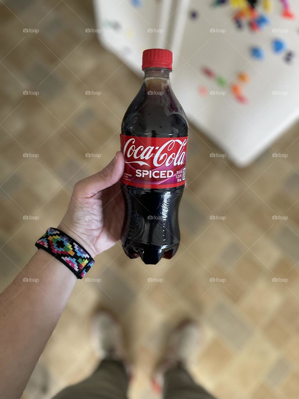 Woman’s hand holding spiced Coca Cola, new flavors of coke, trying Spiced Coca Cola for the first time, woman holds 20 ounce bottle of soda 