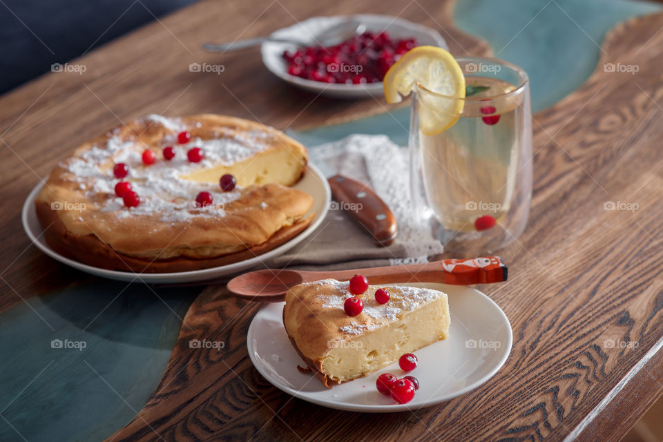 Cheesecake with cranberries and sugar on wooden background