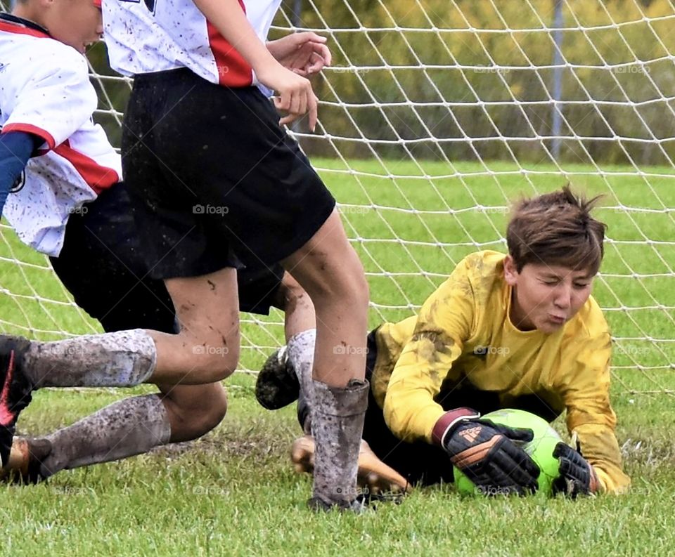 Soccer players all muddy from playing in the rain