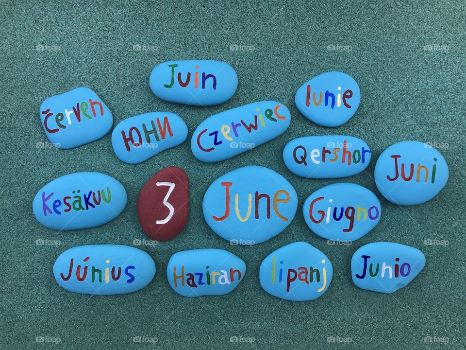 3  June, calendar date with colored stones over green sand