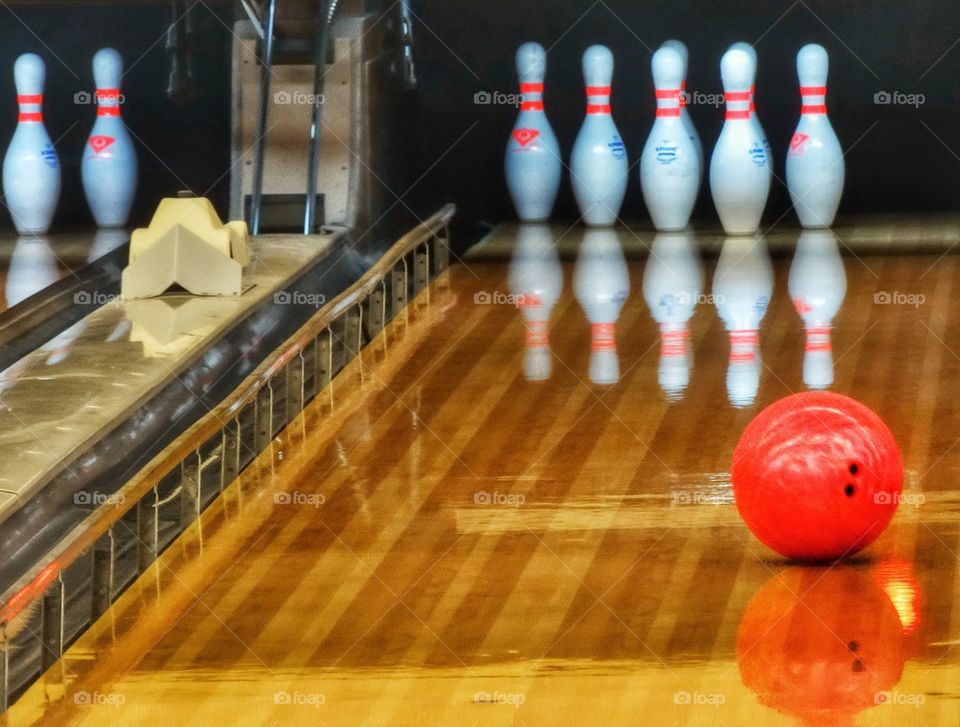 Bowling Ball Hurling Down Hardwood Lane. Bowling Ball About To Hit Bowling Pins In A Bowling Alley
