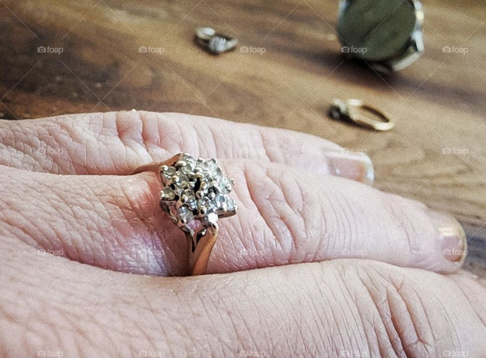 Diamond star cluster ring with rings and a watch in the background.