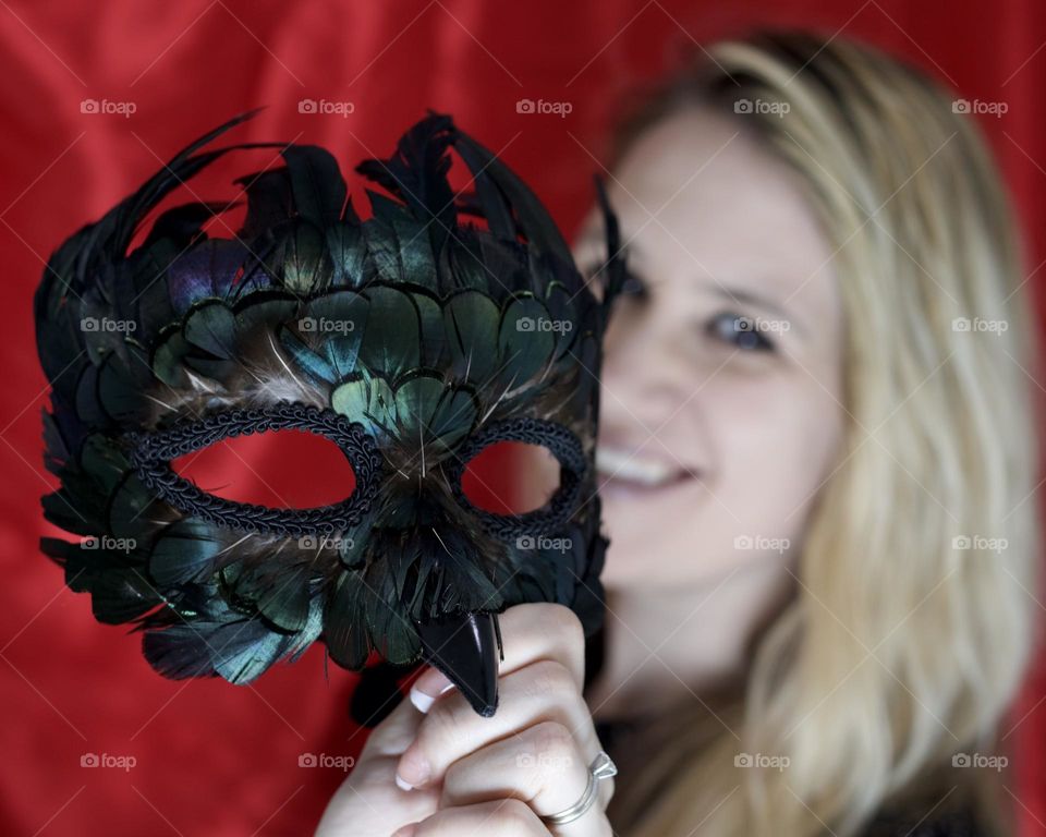 Woman smiling behind Popfizzy Feather Mask