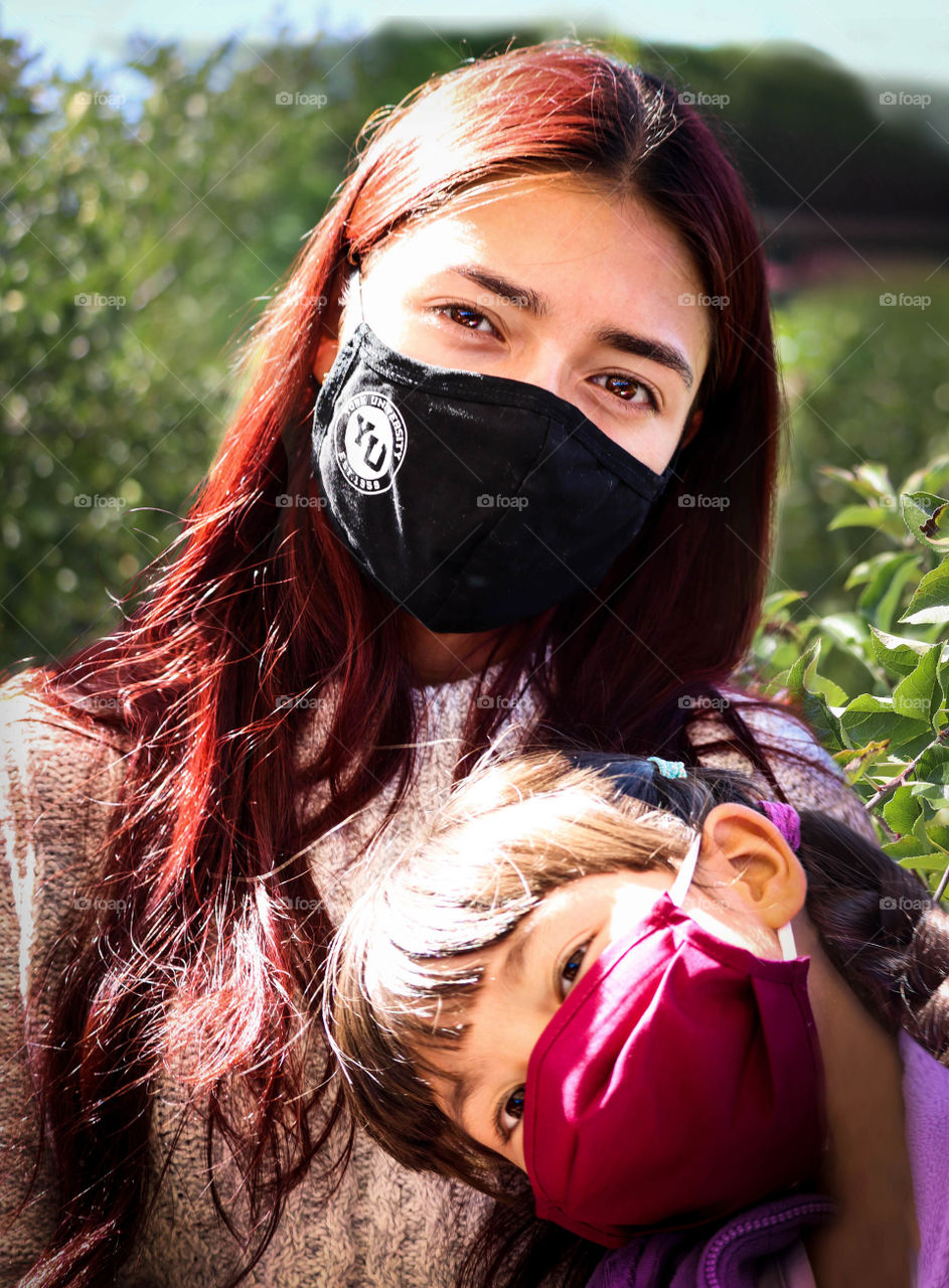 Two girls wearing face masks outdoors