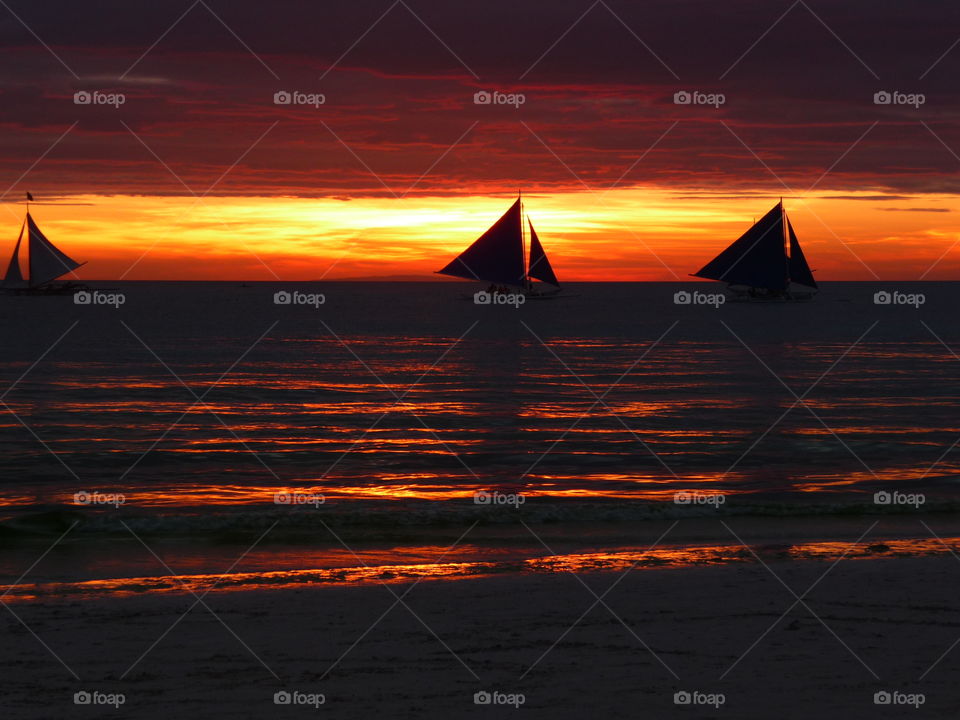 Sunset in the Philippines with Silhouette of boat on the horizon