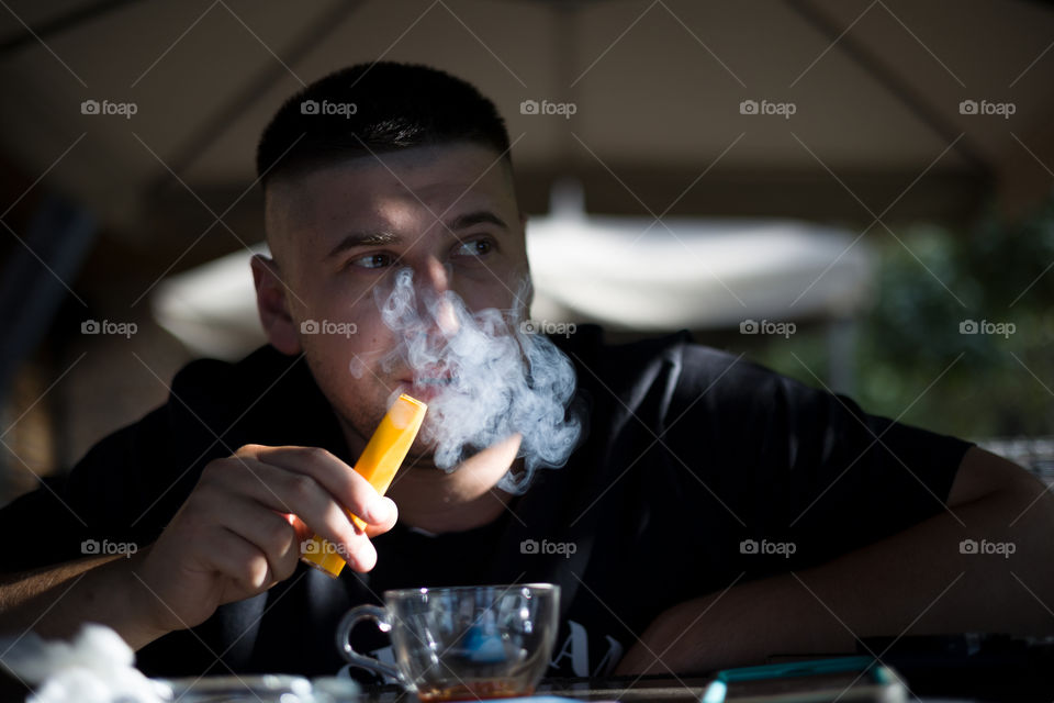 close up portrait of smoking man . electronic cigarette concept