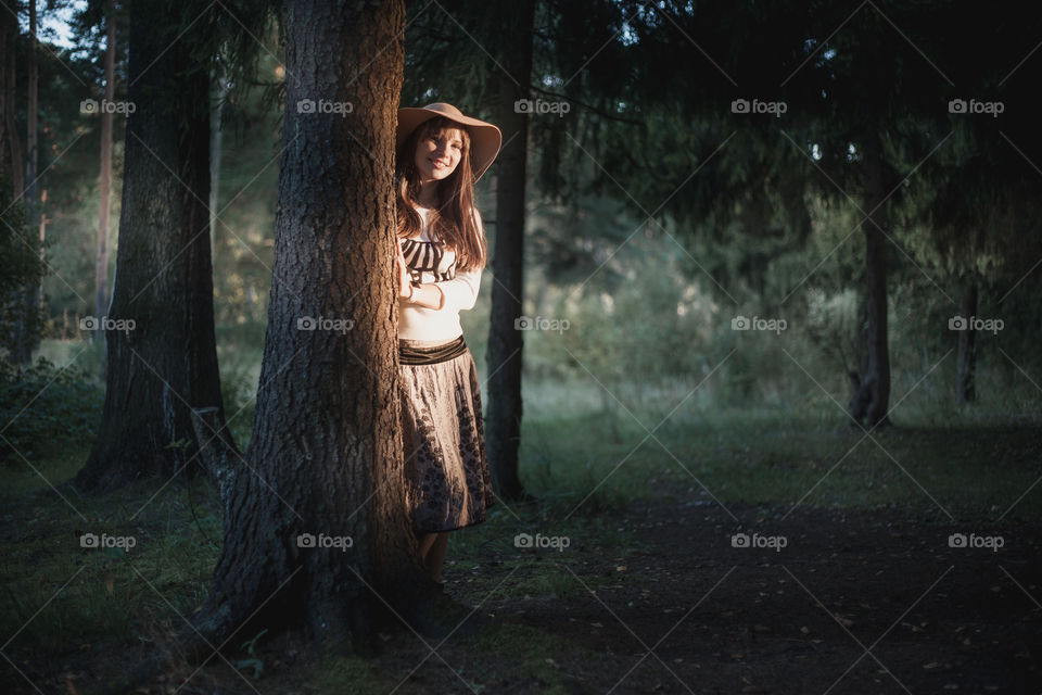 Portrait of Young woman in hat at evening park 