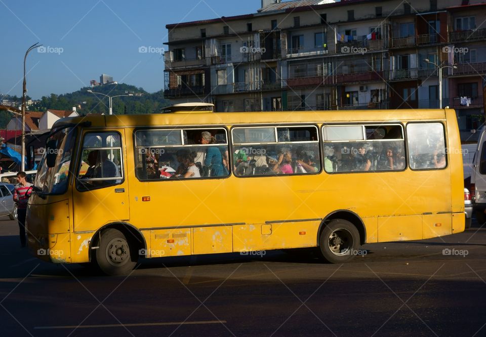 Batumi, Georgia - July 10, 2014: Crowded yellow bus full of unidentified passengers on the one of the main streets in down town Batumi near bus station and harbor in hot summer evening on July 10, 2014.