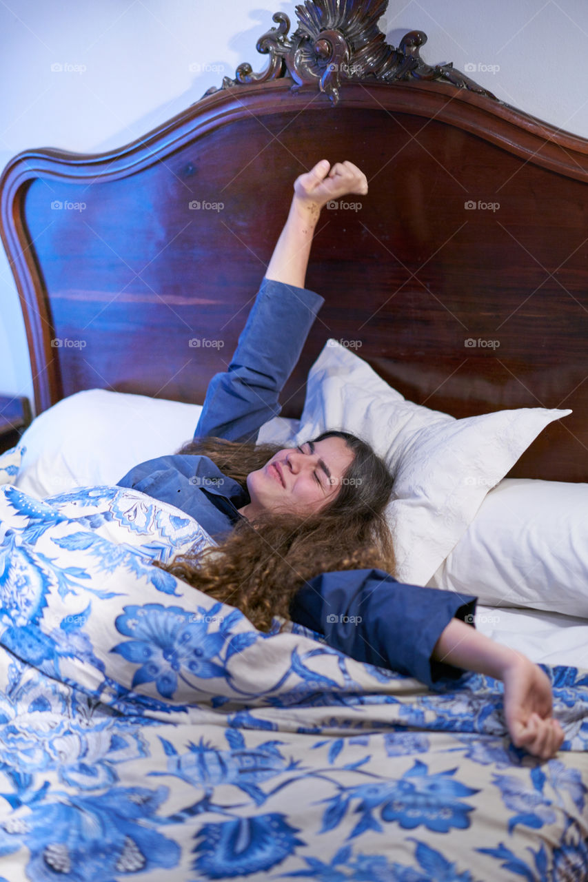 Young woman stretching on bed