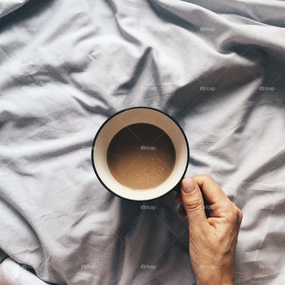 Person's hand holding coffee cup