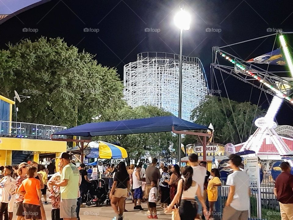 A night at the amusement park bustling with all kinds of people getting together as one.
