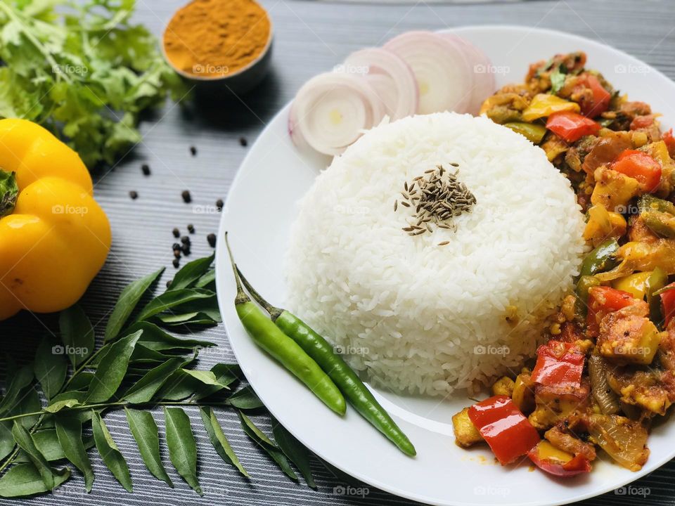 Pannier capsicum curry along with jeera rice and other key Indian ingredients 