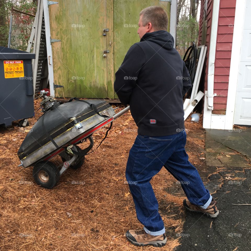 Old heavy TV tube on Dolly moving to Dumpster.
