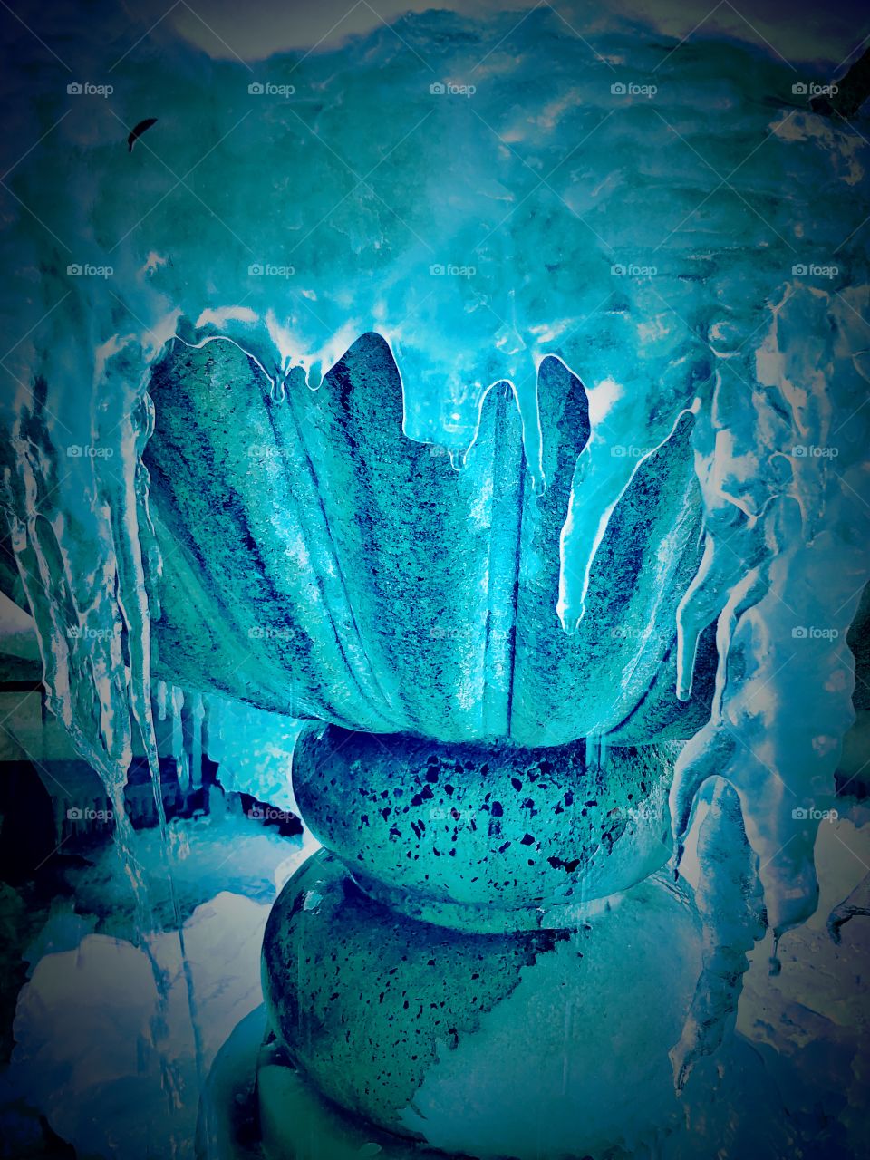 Frozen fountain with dripping icicles close up 