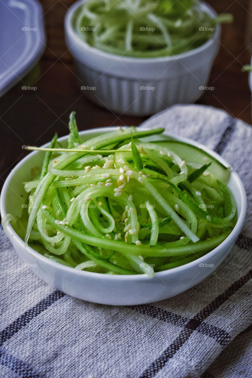 close up shot of cucumber salad served in a bowl