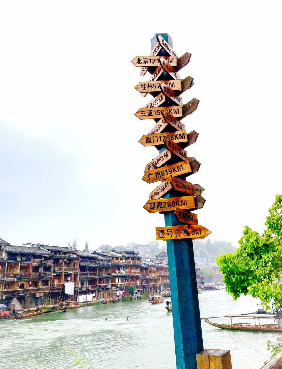 Road signs, river, pile dwellings, boats, Chinese traditional buildings, trees, Phoenix City, Hunan, China