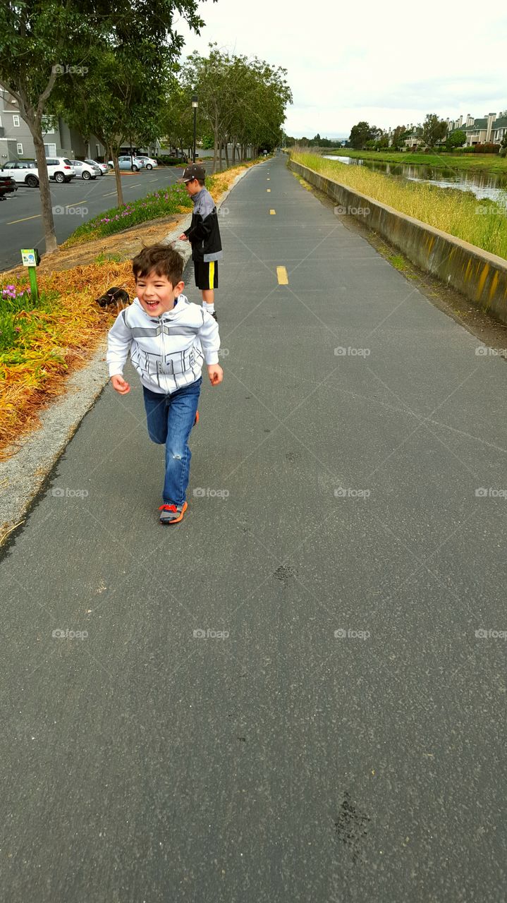 Happy boy running on road